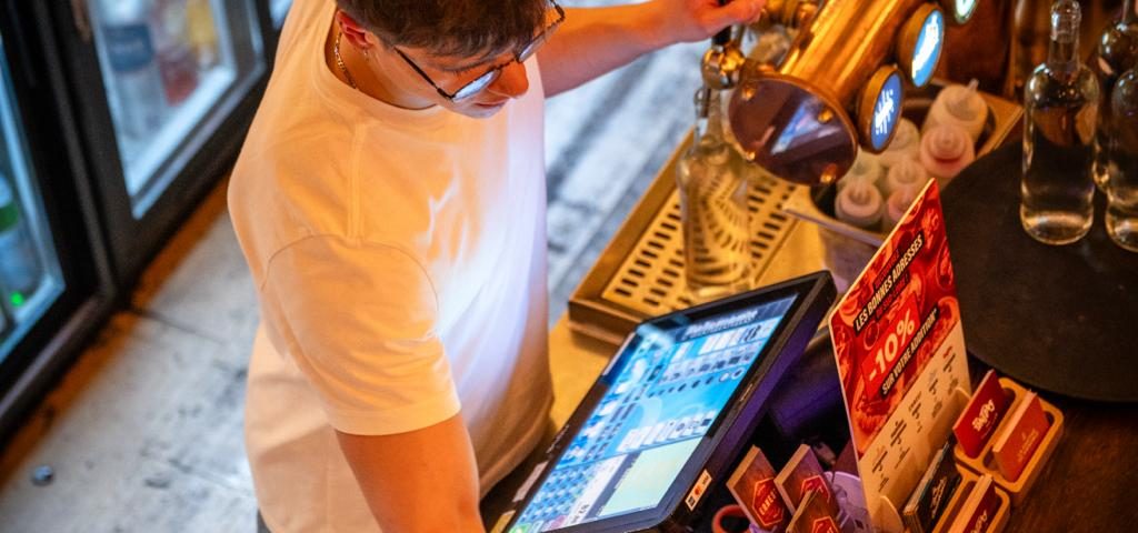 Écosystème numérique des outils gestion restaurant avec une tablette iPad affichant l'interface Zelty connectée aux solutions Kouver et MarketMan.